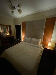 a bedroom with a large white bed with two lamps at Solima pyramids in Cairo