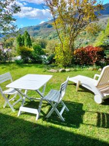 a picnic table and two chairs in the grass at La Cerreta Affittacamere in Poggio