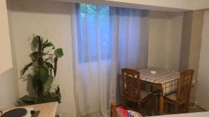 a table and chairs in a room with a window at Mance Apartment in Durrës +6 photos