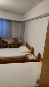 a small room with two beds and a table at Mance Apartment in Durrës