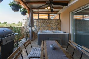 un patio con bañera, mesa y sillas en Apartment Lucia by SeeAdria Agency, en Bužinija