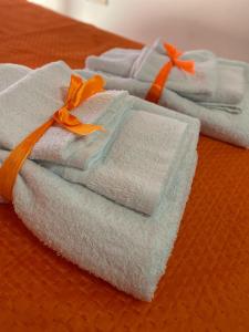 a group of folded towels with an orange ribbon at Casa Nando Relax e comfort home in Marina di Ascea