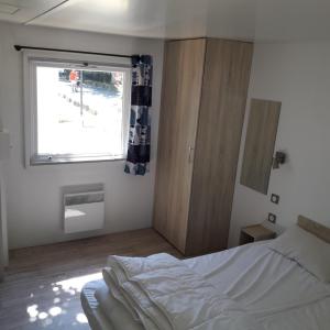 a bedroom with a bed and a window at Village Océanique in Le Bois-Plage-en-Ré