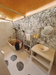 a bathroom with a woman in a tub and a sink at Exotic Private Glamping in Nusa Penida