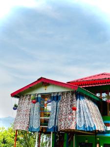 a building with curtains on the side of it at The Chakras Valley Homestay in Almora