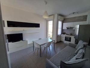 a kitchen and living room with a table and a couch at Appartamento vista mare Misano Adriatico in Misano Adriatico