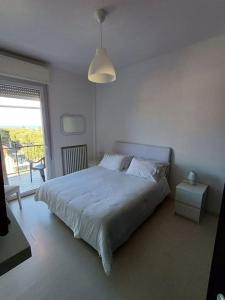 a white bedroom with a bed and a window at Appartamento vista mare Misano Adriatico in Misano Adriatico +38 photos