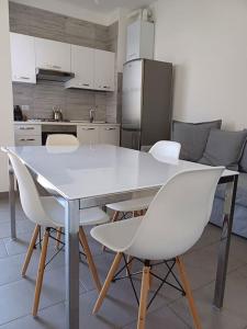 a kitchen with a white table and white chairs at Appartamento vista mare Misano Adriatico in Misano Adriatico