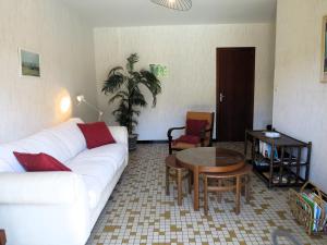 ein Wohnzimmer mit einem weißen Sofa und einem Tisch in der Unterkunft Maison spacieuse avec piscine sur le Bassin d'Arcachon in Lanton
