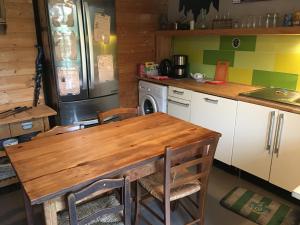 a kitchen with a wooden table and a refrigerator at Au Rendez-Vous des Sorciers II in Aniane