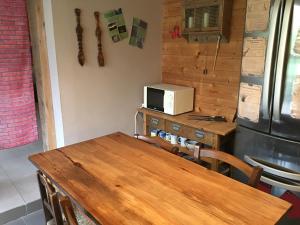 a kitchen with a wooden table and a microwave at Au Rendez-Vous des Sorciers II in Aniane