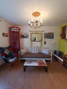 een woonkamer met een bank en een kroonluchter bij Apartment Bella in Ližnjan