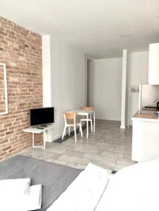 un soggiorno con tavolo e parete in mattoni di Apartament MONSTERA a Bydgoszcz