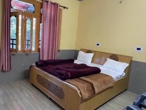 1 dormitorio con 1 cama con sábanas blancas y mantas moradas en Abhi Homestay- Homestay In, en Khajjiar 