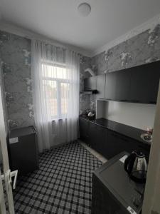 eine Küche mit einem schwarz-weißen Fliesenboden in der Unterkunft Apartment 10 минут от Регистана in Samarkand