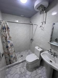 ein weißes Bad mit einem WC und einem Waschbecken in der Unterkunft Apartment 10 минут от Регистана in Samarkand