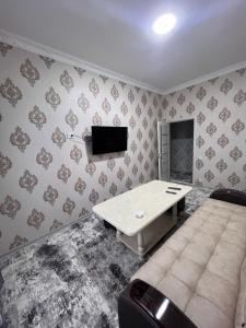 ein Wohnzimmer mit einem Tisch und einem Sofa in der Unterkunft Apartment 10 минут от Регистана in Samarkand