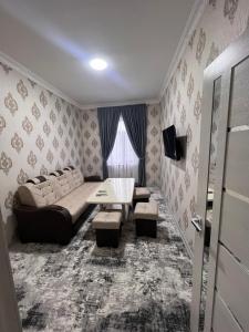 ein Wohnzimmer mit einem Sofa und einem Tisch in der Unterkunft Apartment 10 минут от Регистана in Samarkand