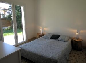 ein Schlafzimmer mit einem Bett und zwei Lampen an zwei Tischen in der Unterkunft Maison spacieuse avec piscine sur le Bassin d'Arcachon in Lanton