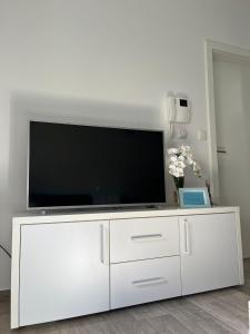 un centro de entretenimiento blanco con TV de pantalla plana. en BRAND NEW lovely apartment Bella, en Dubrovnik