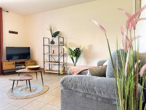 uma sala de estar com um sofá e uma televisão em FARE MOEA - Arue (TAHITI) em Arue