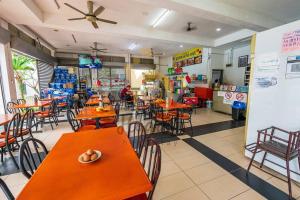 a restaurant with orange tables and chairs in a room at Cozy Resort-Feel 3Bedroom-BBQ, Pool, Netflix 10pax in Seri Kembangan