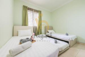 two beds in a room with a suitcase on them at Cozy Resort-Feel 3Bedroom-BBQ, Pool, Netflix 10pax in Seri Kembangan +18 photos