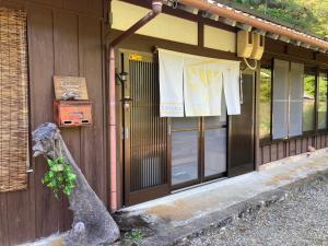 a building with a door with a plant on it at ラコマハウス古座川古民家一棟貸し in Takinohai