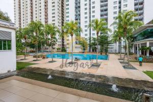 a swimming pool with palm trees and buildings at Cozy Resort-Feel 3Bedroom-BBQ, Pool, Netflix 10pax in Seri Kembangan