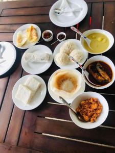 um grupo de pratos de alimentos sobre uma mesa em Lotus cool hotel and restaurant em Ibbagomuwa