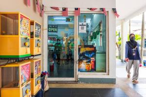 a man walking in front of a store at Cozy Resort-Feel 3Bedroom-BBQ, Pool, Netflix 10pax in Seri Kembangan