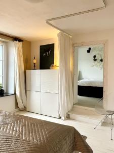 una camera da letto con un letto e un grande specchio di Maison ardennaise à Corbion-sur-Semois a Bouillon Altre 27 foto