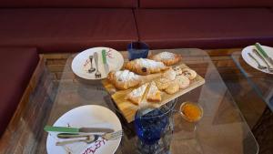 a glass table with plates and pastries on it at B&B Le Vie del Borgo in Castiglione di Sicilia