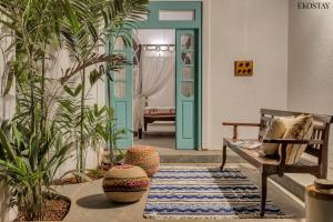 a living room with a bench and some plants at EKOSTAY - Blue Tiffany Villa in Nerul +21 photos