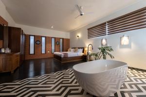 a bathroom with a tub and a bedroom with a bed at Asta in Ooty