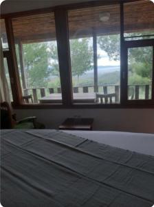 a bedroom with a bed and a window with a view at İda bay bungolow in Edremit