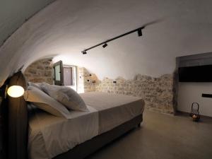 1 dormitorio con 1 cama en una habitación con una pared de piedra en Sophia Town Square Areopoli en Areopolis