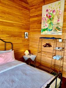 a bedroom with a bed and a painting on the wall at Rang Robin Farmstay for 4 with pool in Ban Wang Muang