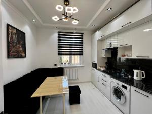 cocina con mesa, lavadora y secadora en New Apartment near the Savitsky Museum and Central Bazaar en Nukus