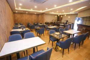 a restaurant with tables and chairs and a bar at Golden Nasmir Hotel in Bukit Mertajam
