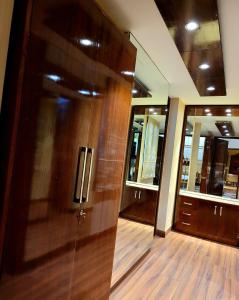 drewniane drzwi w pokoju z lustrem w obiekcie Victorian Elegance Luxury Stays w mieście Amritsar