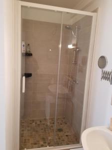 La salle de bains est pourvue d'une douche avec une porte en verre. dans l'établissement Le flamant rose, à Arles
