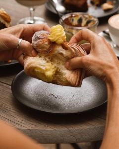 a person holding a piece of food on a plate at The Lofts Boutique Hotel in Knysna