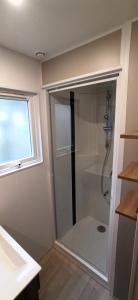 La salle de bains est pourvue d'une cabine de douche et d'une fenêtre. dans l'établissement Camping Larribal, à Millau