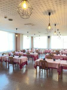 a restaurant with pink tables and chairs and windows at Felse Inn Gakusui in Hakuba