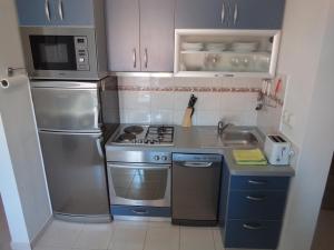 Una cocina con frigorífico de acero inoxidable y fregadero. en Adriatic Arteon, en Baška