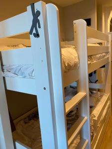 Ce lit se trouve dans un dortoir doté de 2 lits superposés blancs. dans l'établissement Le Gabiott, Appartement neuf pour 4, au pied des pistes à La Rosière, à Montvalezan