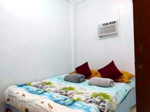a bed with two pillows on it in a room at RM3 - Ground Floor Unit in San Roque Bauan Batangas in Batangas City