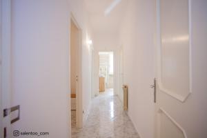 a hallway with white walls and a white hallway with a door at SeaBreeze Gallipoli - Lido San Giovanni in Gallipoli