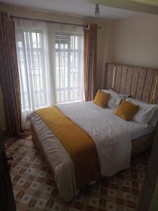 - une chambre avec un grand lit en face d'une fenêtre dans l'établissement The seed, à Nairobi